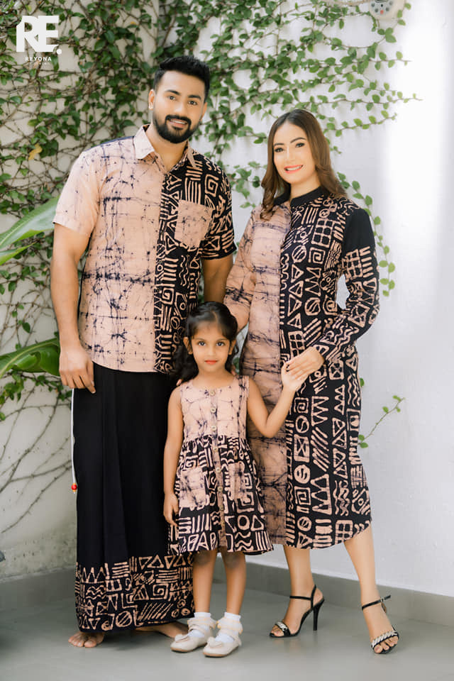 Woman wearing a handmade dual-tone beige and black long batik dress with geometric prints, from Reyona Clothing – RE-0006