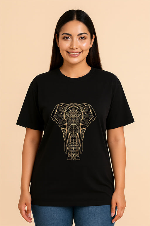 Female model wearing a black oversized unisex T-shirt with a detailed gold elephant graphic by REYONA.