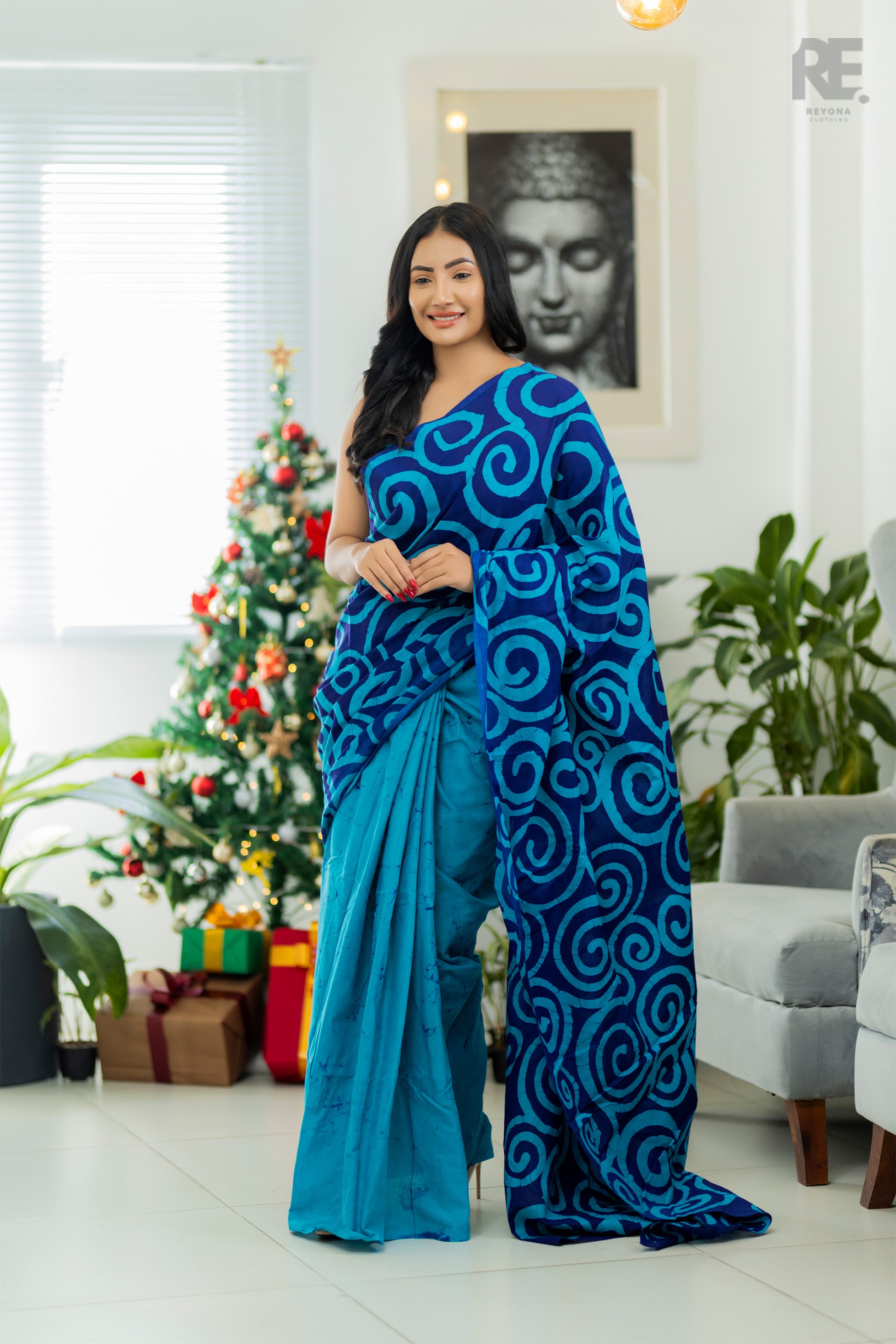 Woman wearing a blue and aqua handcrafted batik saree with swirl patterns — Batik Saree RE-0051 I REYONA Clothing Australia