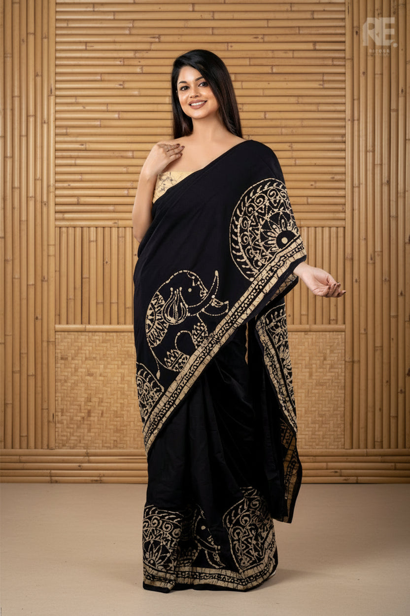 Woman wearing a black designer batik saree with golden traditional patterns I Batik Saree RE-0102