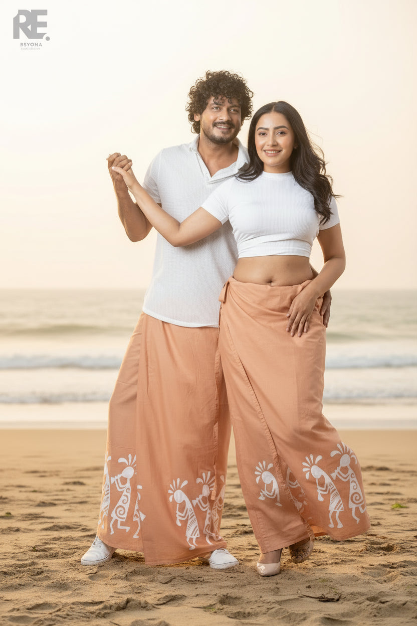 Man and woman wearing matching terracotta hand-painted batik unisex sarongs with white tribal motifs, from Reyona Clothing – RE-0087