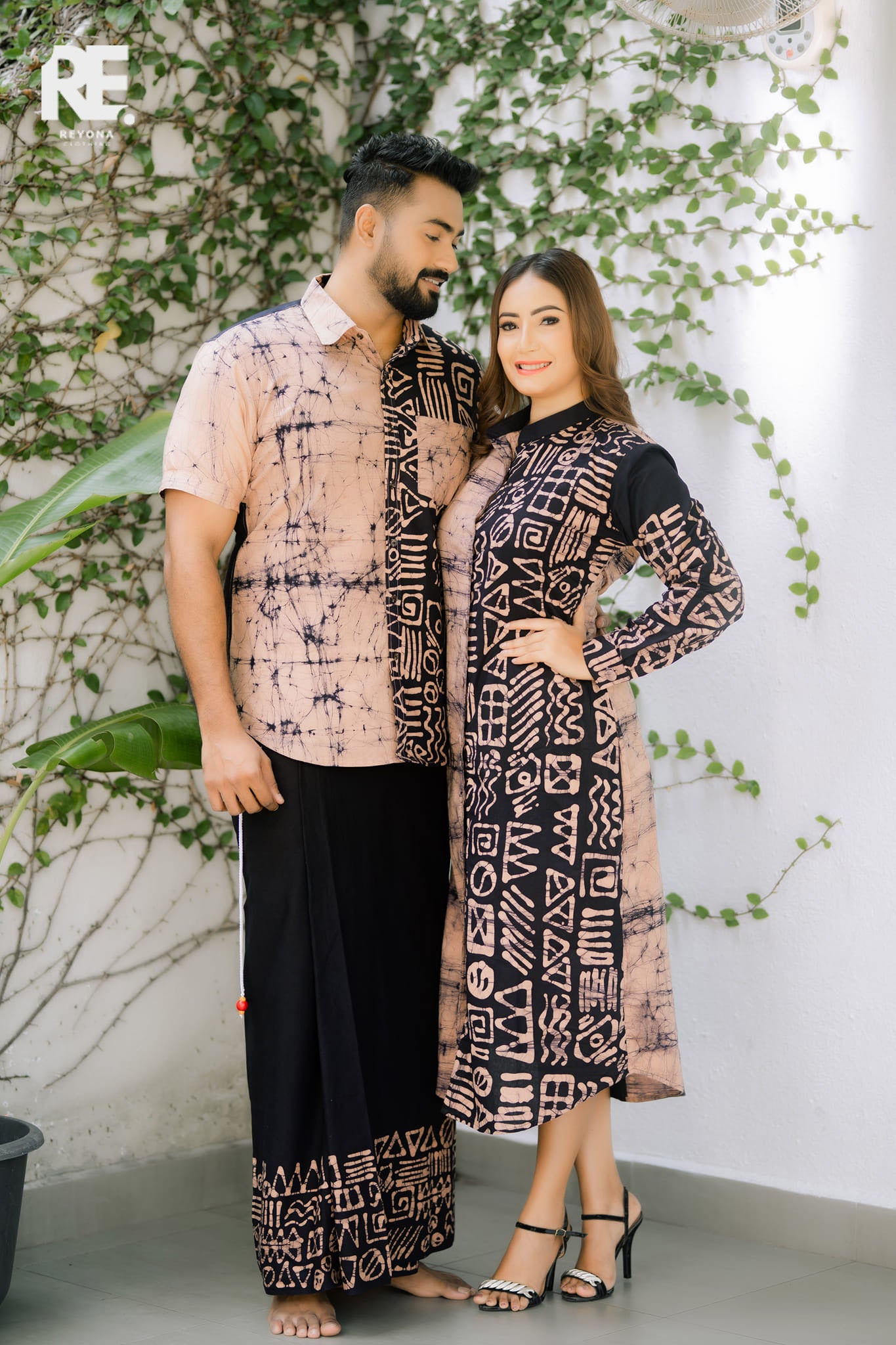 Woman wearing a handmade dual-tone beige and black long batik dress with geometric prints, from Reyona Clothing – RE-0006