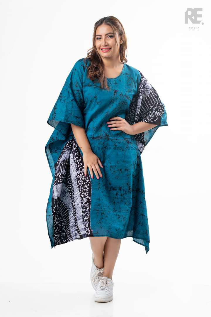 Woman wearing a handmade teal batik kaftan dress with black and white batik detailing, from Reyona Clothing – RE 0005