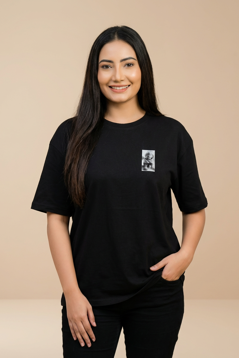 Oversized unisex black graphic T-shirt with small monochrome chest print worn by female model – RE-0119