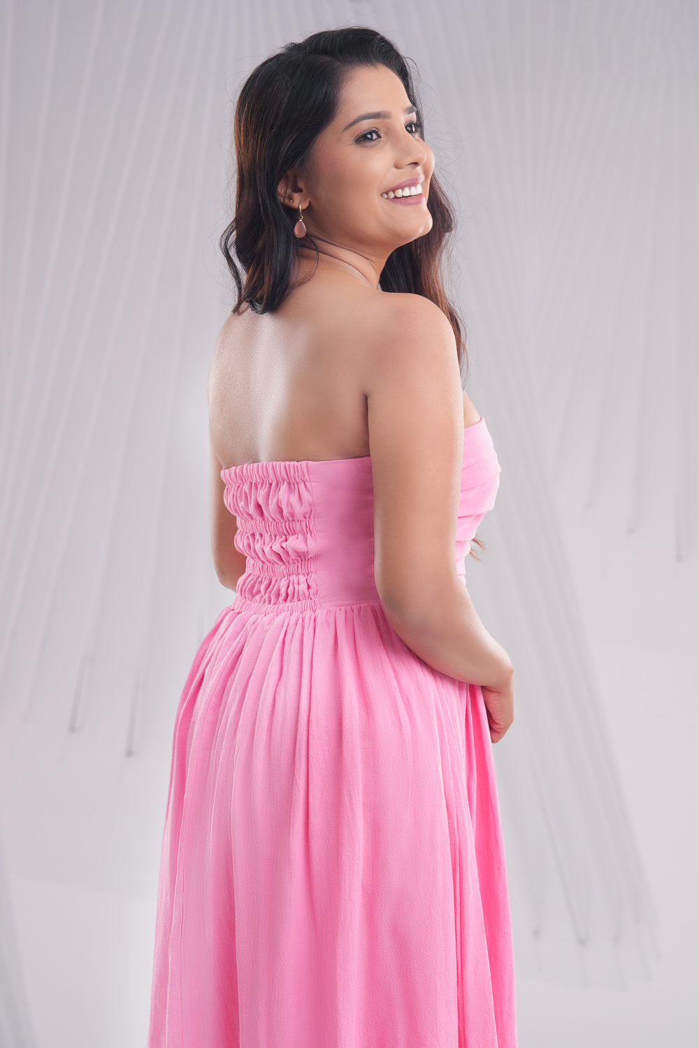 Front view of peach strapless midi dress with pleated bodice